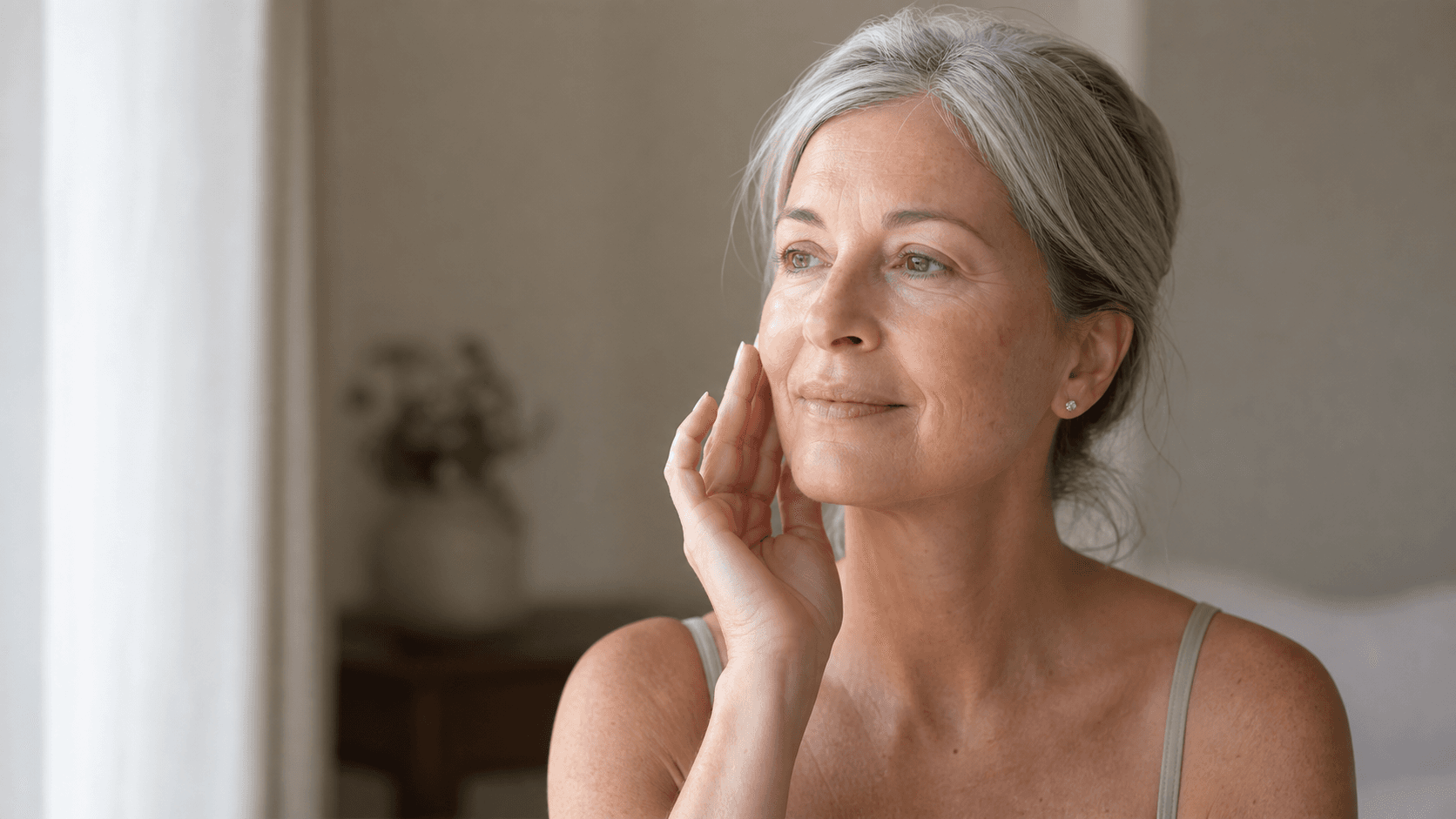 Mulher madura tocando suavemente a face com textura natural da pele