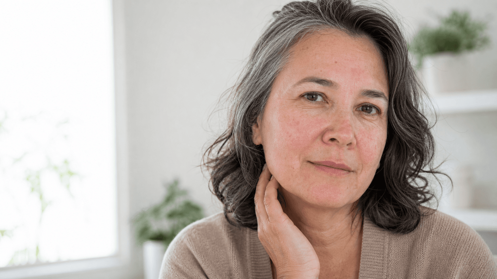 Mulher madura com textura real e vermelhidão facial leve em luz natural